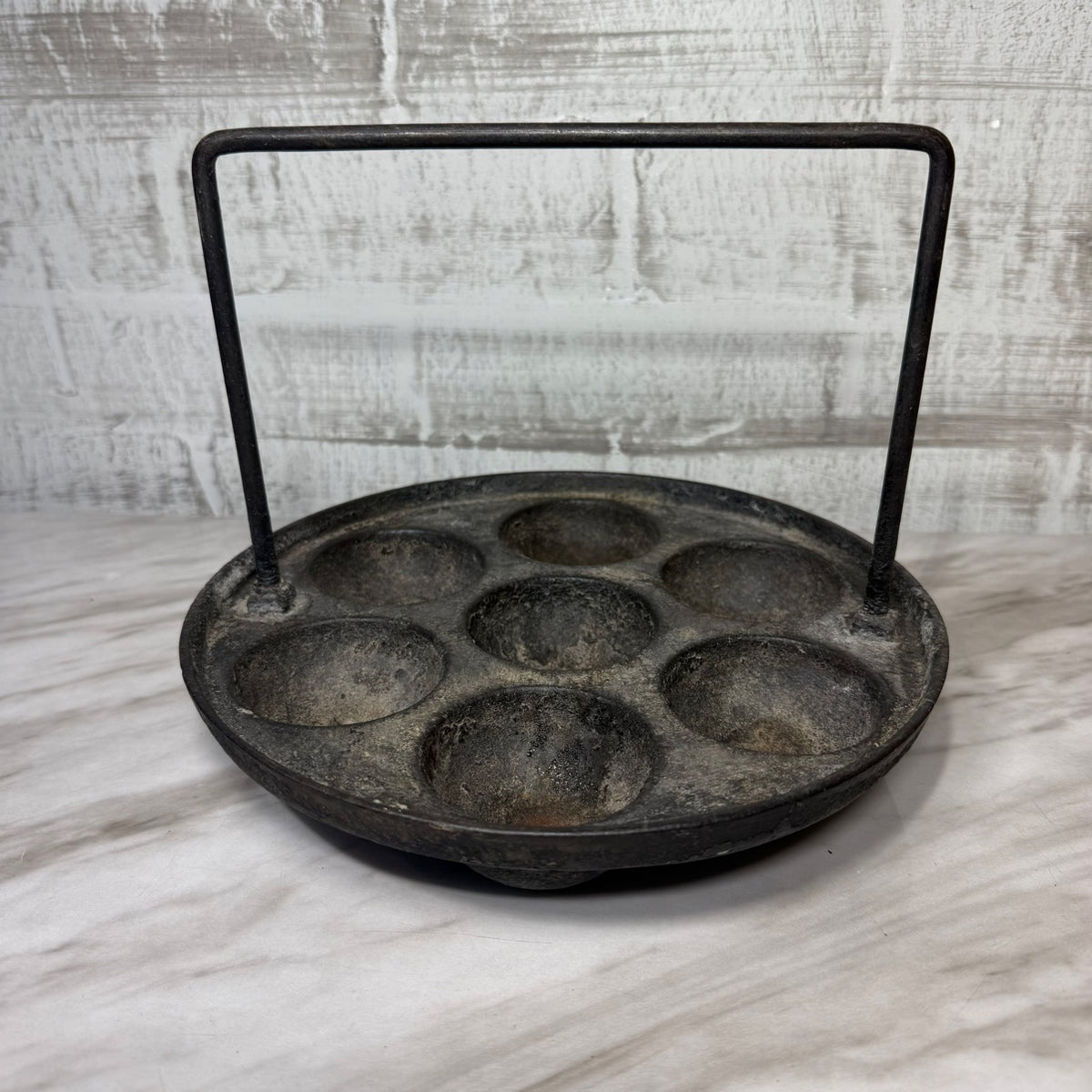 Antique cast iron aebleskiver pan with bail handle, front view