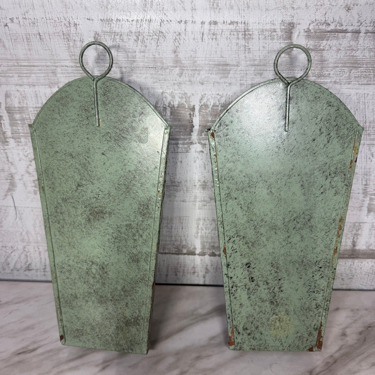 Set of 2 sage green metal wall pocket planters, back view