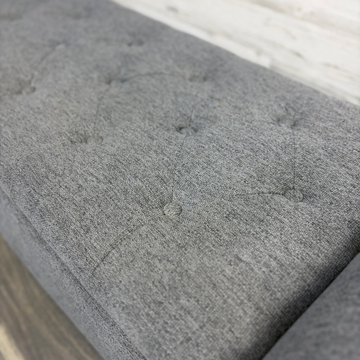 Gray upholstered bench, angled view