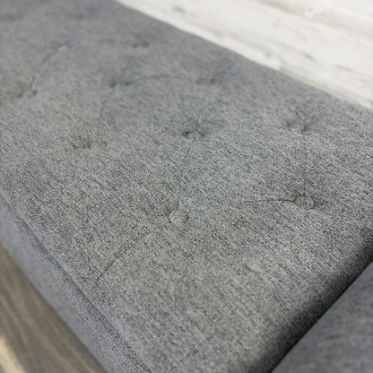 Gray upholstered bench, angled view