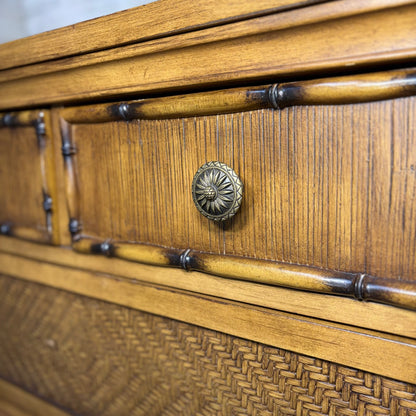 Closeup of pineapple-motif brass knob, bamboo trim, and woven rattan drawer front