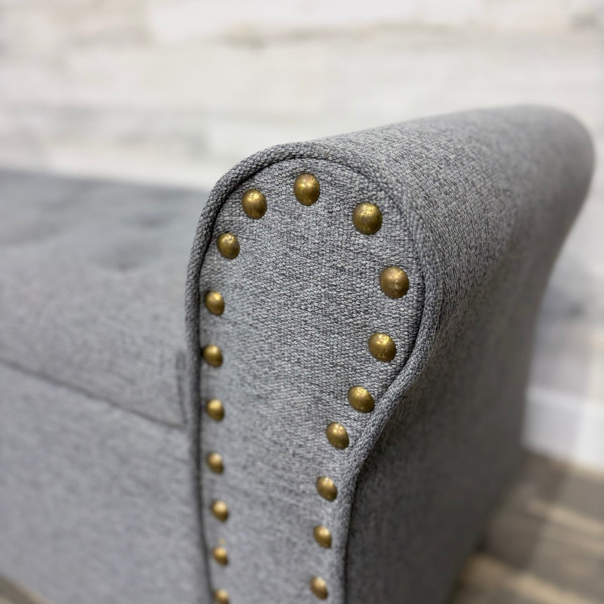 Close-up of brass nailhead trim on rolled arm